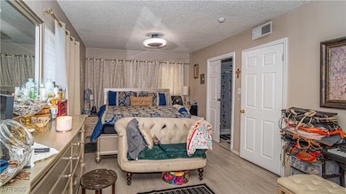 Bedroom featuring a textured ceiling and light wood-type flooring