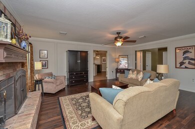 A wood-burning fireplace anchors the den, which is sure to be a favorite gathering spot.