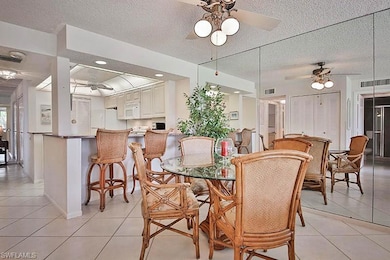 Dining room with a ceiling fan, light tile patterned flooring, and a textured ceiling