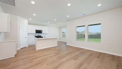 Kitchen with recessed lighting, a center island with sink, light wood-style flooring, white cabinetry, and appliances with stainless steel finishes