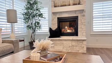 Living area with wood finished floors and a warm lit fireplace
