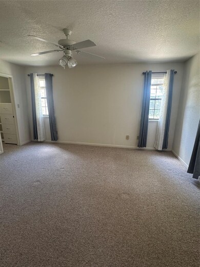 Carpeted spare room featuring a textured ceiling,