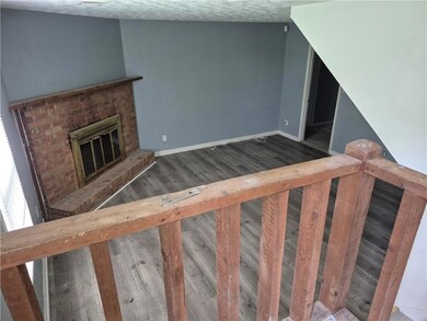 Staircase featuring wood finished floors, baseboards, and a fireplace