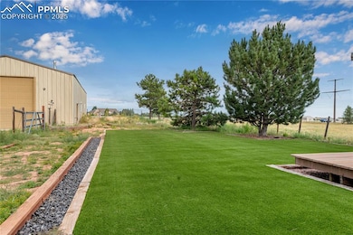 View of green lawn with an outdoor structure and a detached garage