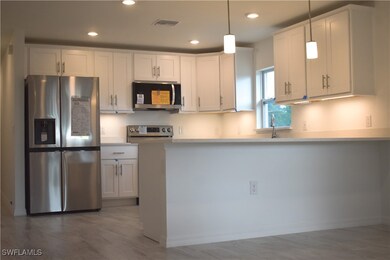 Kitchen with white cabinetry, light countertops, s