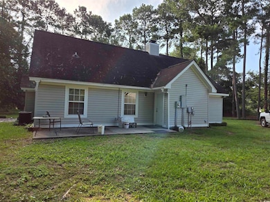 Back of property featuring a patio area and a lawn