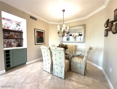 Tiled dining room featuring ornamental molding and