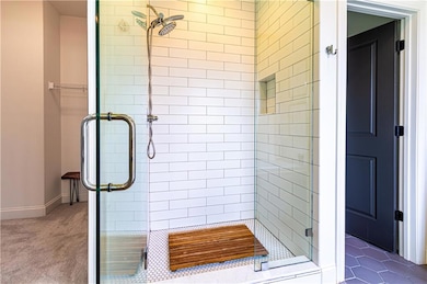 Bathroom featuring a shower with shower door and tile floors