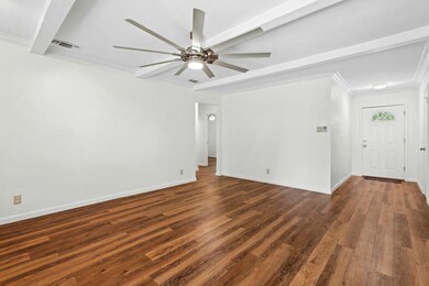 Spare room featuring ornamental molding, dark woo