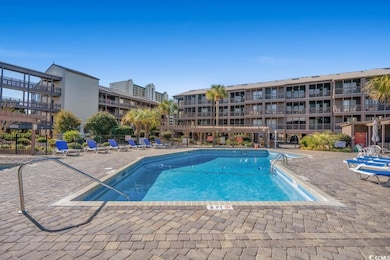 Community pool with a patio and fence
