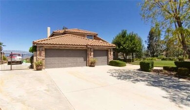 Expansive front yard with ample parking and gated 