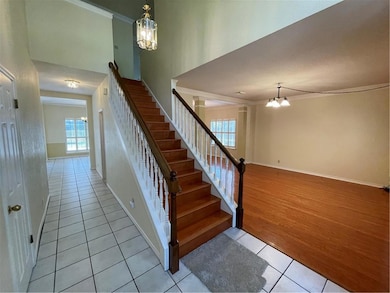 Stairs with a chandelier, tile patterned flooring