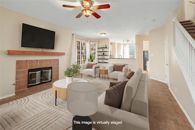 Living area featuring ceiling fan, stairs, a fire