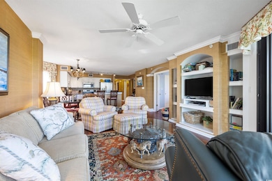 Living room featuring crown molding, built in shel