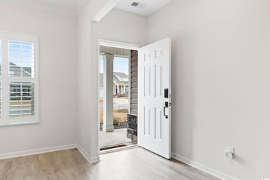 Entryway with visible vents, ornamental molding, baseboards, and wood finished floors