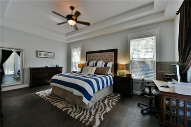 Master bedroom with hardwood floors and double tra