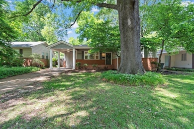 Ranch-style house with brick siding, driveway, and an attached carport