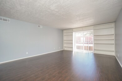 Spacious living room with built-in shelving.  New