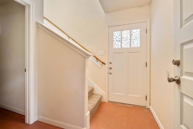 Foyer entrance with stairway and baseboards