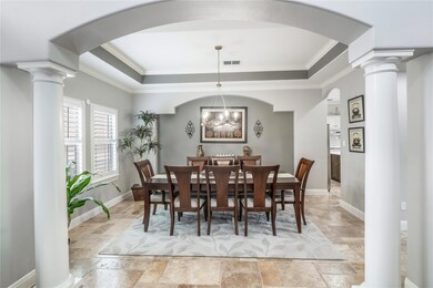 Dining area with ornate columns, stone tile floor