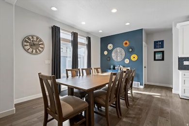 Dining space with dark wood-style floors and recessed lighting