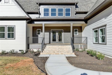 View of exterior entry featuring covered porch, french doors, a shingled roof, and crawl space