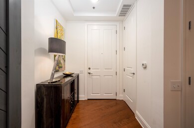 Entryway featuring visible vents, dark wood-style 