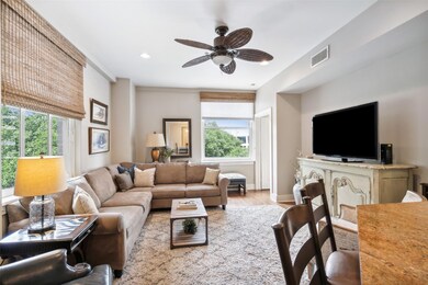 Living room with ceiling fan and light wood-type f