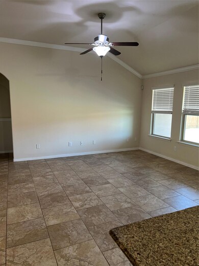 Spare room featuring a ceiling fan, crown molding