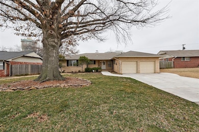 Ranch-style home featuring a garage, fence, and br