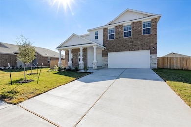 View of front of property featuring brick siding, driveway, an attached garage, and a porch