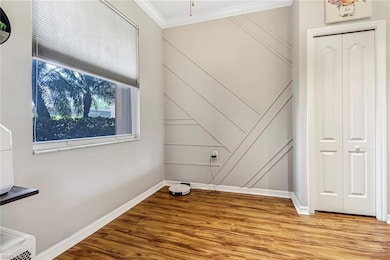 Unfurnished bedroom with ornamental molding, wood-type flooring, and a closet