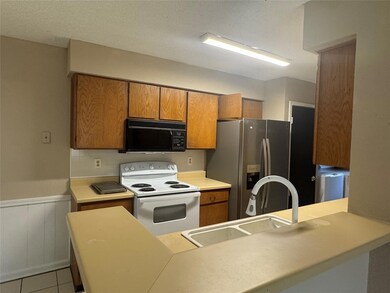Kitchen featuring black microwave, white range wi