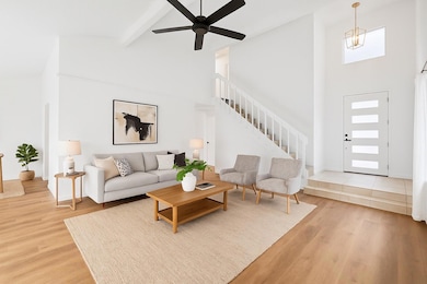 Living room featuring high vaulted ceiling, stair