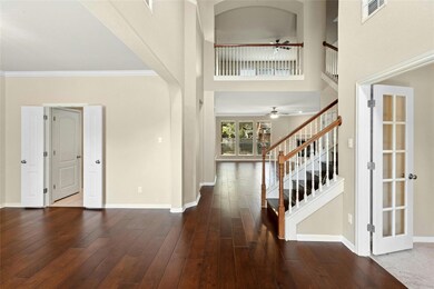 Foyer featuring ceiling fan, stairs, baseboards, a towering ceiling, and ornamental molding