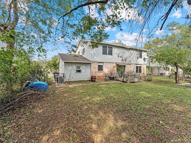 Back of property with brick siding and a yard