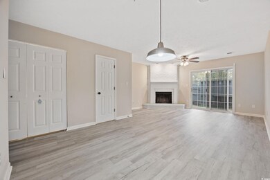 Unfurnished living room with baseboards, a large fireplace, light wood-type flooring, and a ceiling fan