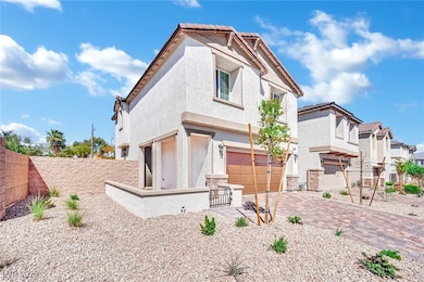 Rear view of house with stucco siding, a garage, decorative driveway, and stone siding
