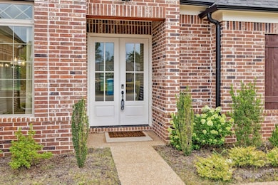 Doorway to property with brick siding and french doors