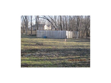 Back yard of home showing lots of trees and the fe