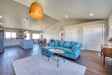 Living area with lofted ceiling, recessed lighting, and dark wood-type flooring