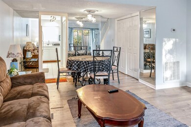 Dining space featuring light wood-style floors, a chandelier, baseboards, and a textured ceiling