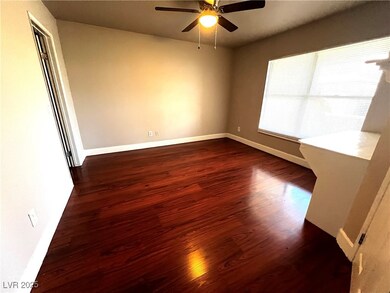 Empty room with dark wood-style flooring and a ceiling fan