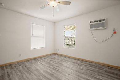 Empty room with wood finished floors, a ceiling f