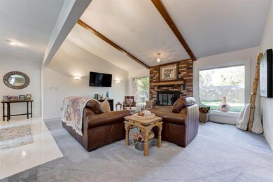 Living room with vaulted ceiling with beams, light