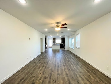Unfurnished living room featuring recessed lighting, healthy amount of natural light, dark wood-type flooring, and a ceiling fan