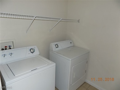 Laundry room featuring washer and clothes dryer and light tile patterned floors