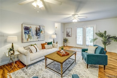 Living room featuring wood-type flooring and ceiling fan