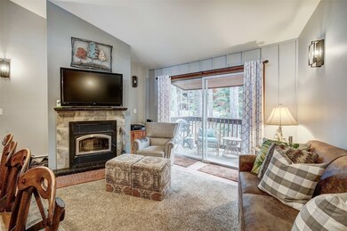 Carpeted living room featuring vaulted ceiling and