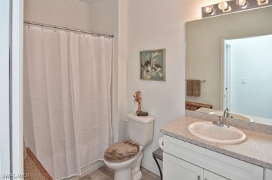 Full bathroom featuring toilet, a shower with curt